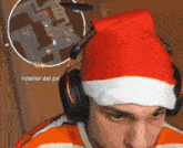 a man wearing headphones and a santa hat is playing a game