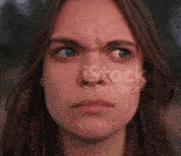 a close up of a woman 's face with an angry look on her face ..