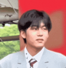 a young man wearing a suit and tie is making a funny face .