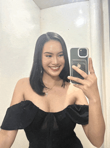 a woman taking a picture of herself with her phone