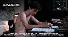 a shirtless man is sitting at a desk writing on a piece of paper
