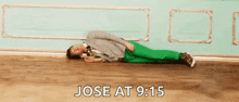 a man in green pants is laying on the floor with the words jose at 9:15 above him .