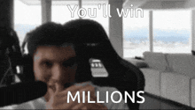 a man sitting in front of a microphone with the words you 'll win millions on the bottom