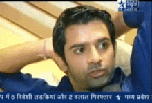 a man in a blue shirt is on a tv screen with a star in the upper left corner
