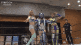 three female wrestlers in a ring with the word stardom on the bottom left