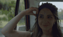 a woman is sitting in a car with her hand on her head