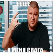 a man in a black shirt is giving the middle finger and has the word eeeee in white letters above him
