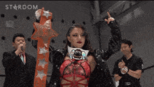 a woman stands in front of a sign that says stardom on it
