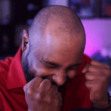 a bald man with a beard is making a face with his hands