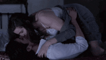 a man and woman are kissing on a bed