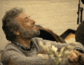 a man with a beard is smiling while holding a bouquet of flowers