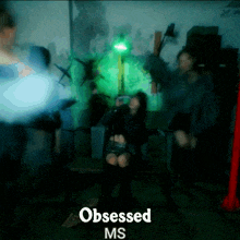 a blurry picture of a woman sitting in a chair with the words obsessed ms on the bottom