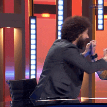 a man with a beard is sitting at a desk with a sign that says passcode