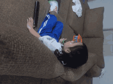 a little girl laying on a couch with a toy in her hand that says ' disney ' on it