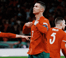 a soccer player wearing an orange jersey with the number 5 on it