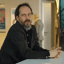 a man with a beard is sitting at a table