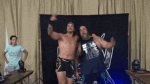 two wrestlers are posing for a picture and one has a shirt that says kill the ref