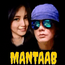 a man and a woman wearing sunglasses and a blue hat are standing next to each other on a poster .