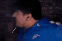 a blurry picture of a man in a blue jacket making a face .