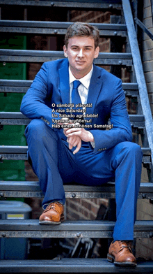 a man in a blue suit sits on some stairs