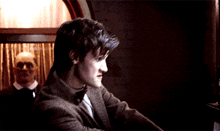 a man in a suit and tie is looking down
