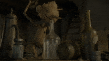 a statue of groot sits on a table next to a bottle of wine
