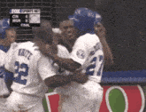 a group of baseball players are hugging each other and the scoreboard says fox sports net in the background