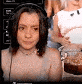 a woman wearing headphones is sitting in front of a computer screen