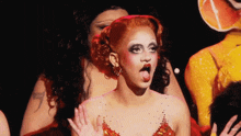 a woman with red hair is making a funny face with her mouth open