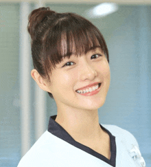 a woman with a bun in her hair is smiling