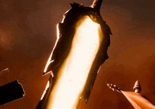 a sword with a flame coming out of it in the dark