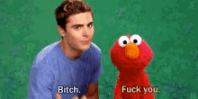 a man standing next to a stuffed animal that says bitch fuck you .