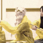 a girl with a flower crown on her head is wearing a yellow raincoat with qqlovepuppy written on the bottom