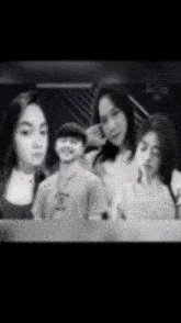 a group of people are posing for a picture together in a black and white photo .