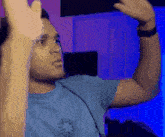 a man wearing a blue shirt with a clock on it is making a funny face