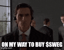 a man in a suit and tie is wearing headphones and says " on my way to buy $sweg "