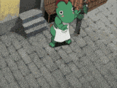 a green frog mascot with a white apron on stands on a brick sidewalk