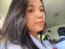 a girl with long dark hair is sitting in a classroom