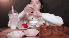 a woman drinking from a plastic cup with a straw