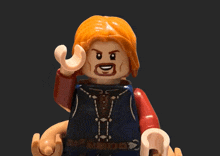 a lego figure with red hair and a beard is waving his hand