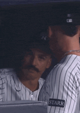 a woman wearing a ny hat looks at something in the distance