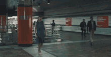 a woman in a blue dress is dancing in a subway
