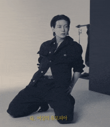 a black and white photo of a man kneeling down with q. written in yellow