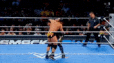 two men are wrestling in a ring with a referee watching
