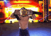 a man holding a wwe championship belt over his face