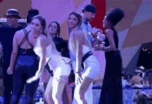 a group of women are dancing together in a dark room .