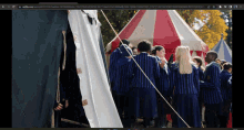 a group of people standing in front of a tent with the url netflix.com at the top of the screen