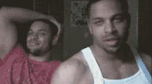 two men are standing next to each other with their arms over their head .