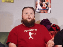 a man with a beard is wearing a red t-shirt that says touchdown