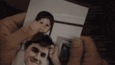 a person is holding a picture of a man and a little girl